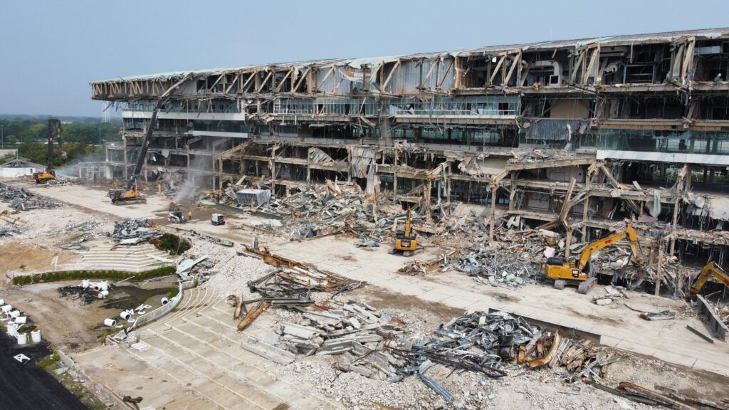 An aerial view of a large building being demolished.