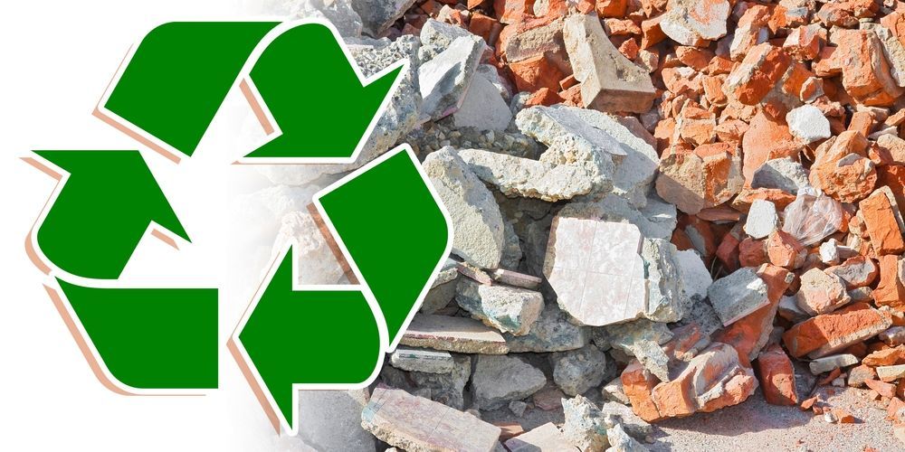 There is a recycling symbol next to a pile of rocks and bricks.