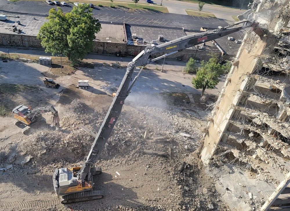 An aerial view of a building being demolished with a crane.