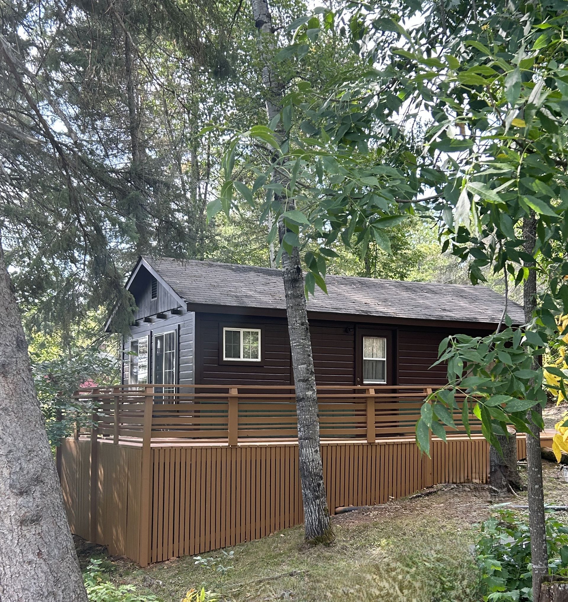 there are two chairs on the deck of a house .