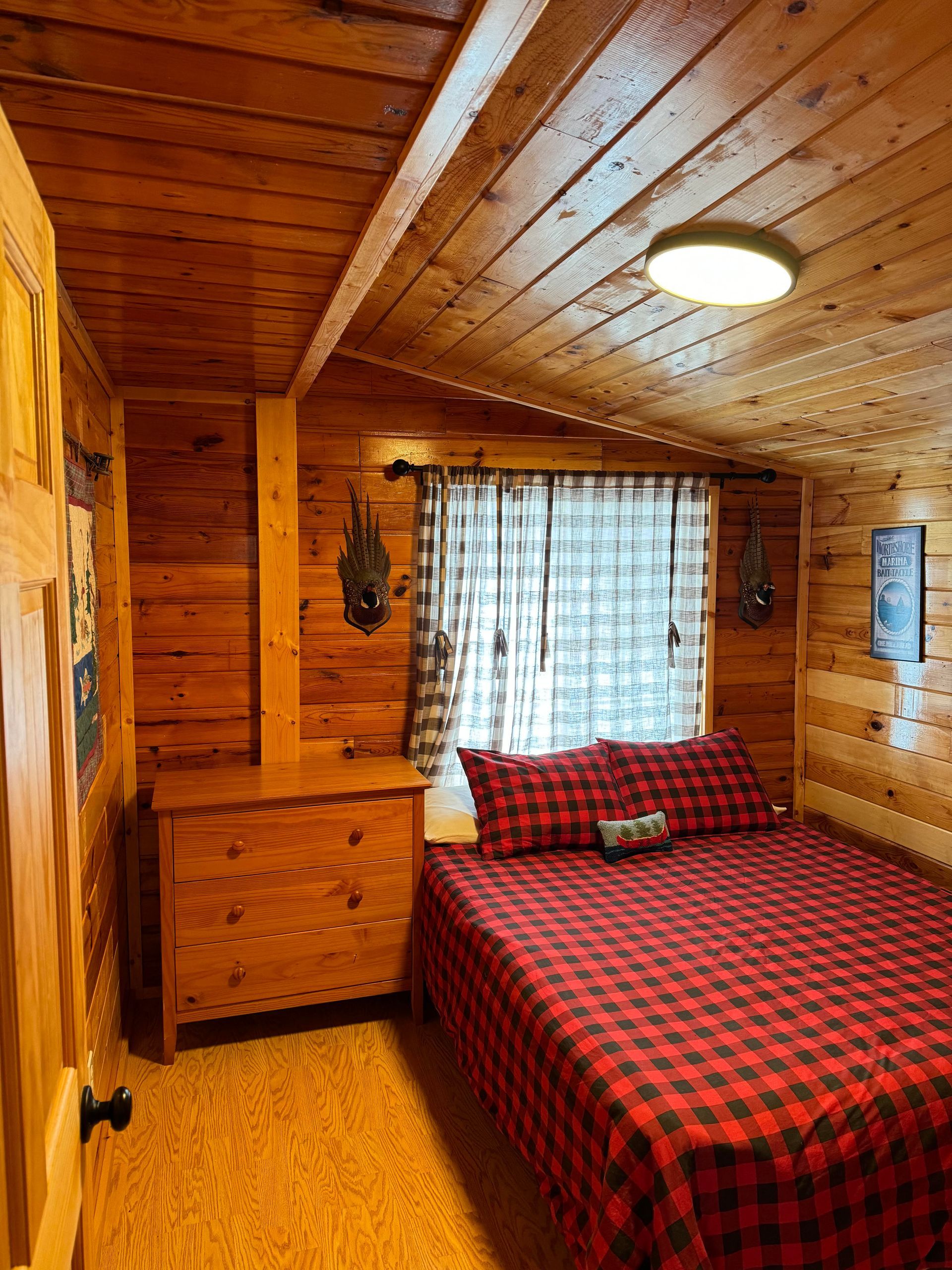 a bedroom in a log cabin with a bed and dresser .