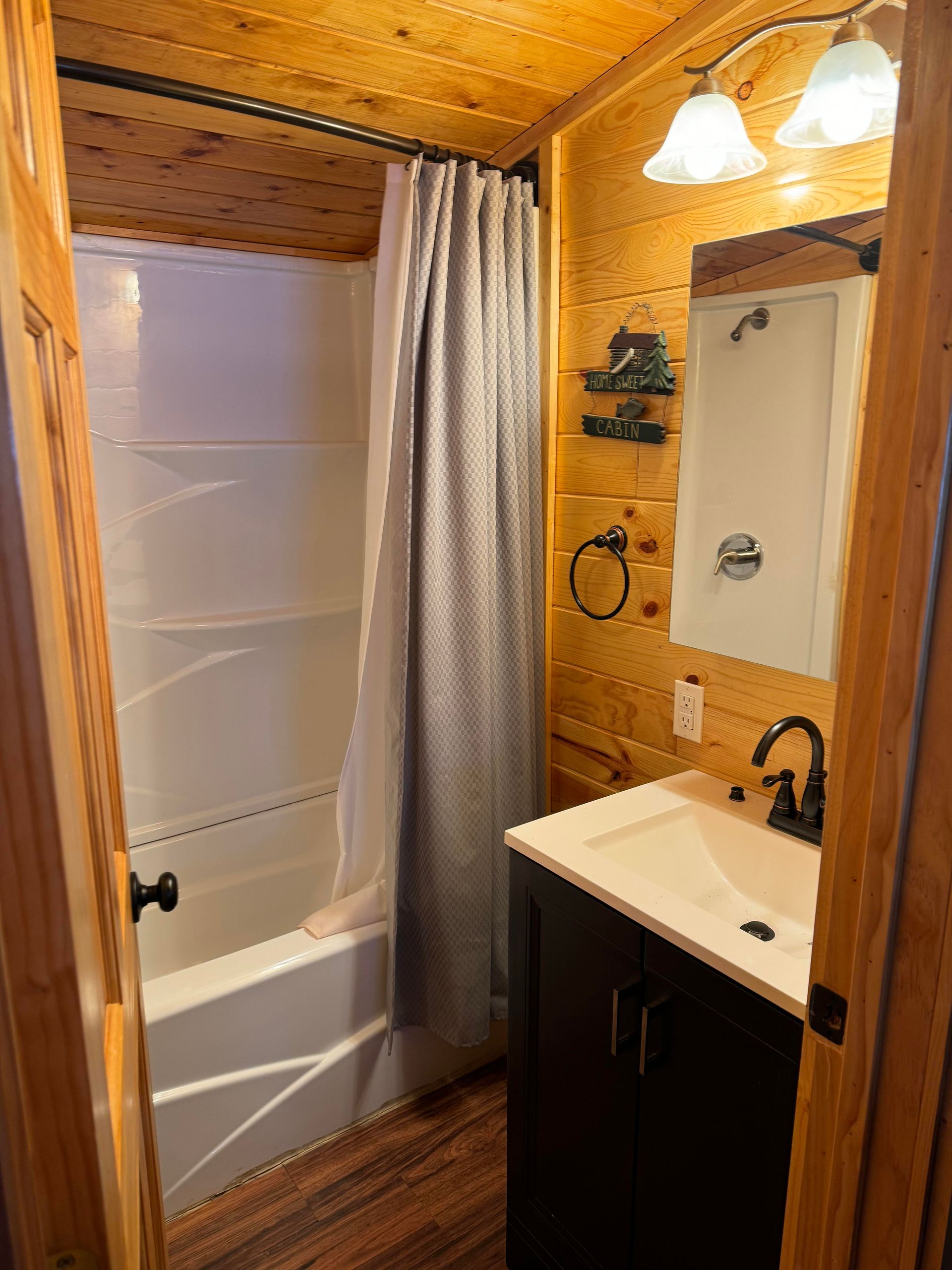 a bathroom with a sink , tub , shower and mirror .