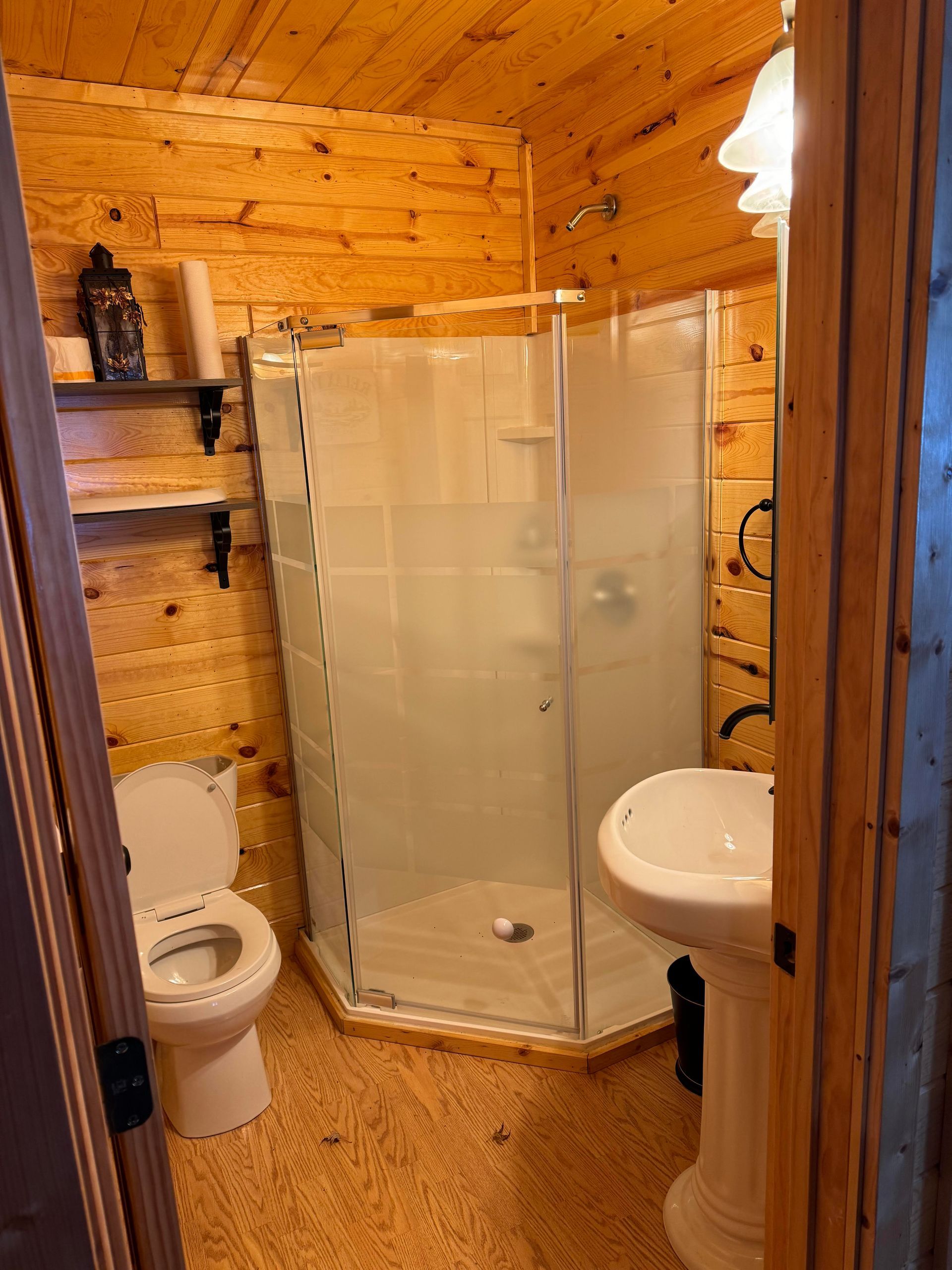 a bathroom with a toilet , sink and shower .