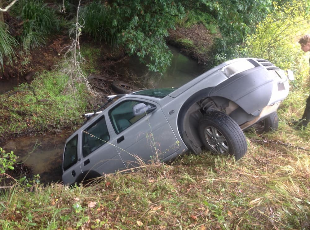 Silver Vehicle On Edge Of Hill Into Embankment— Alpine Towing Services in Lismore, NSW