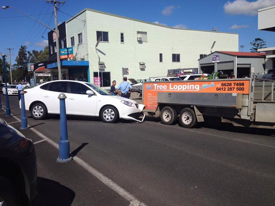 A White Car Is Being Towed By A Tree Lopping Truck — Alpine Towing Services in Lismore, NSW