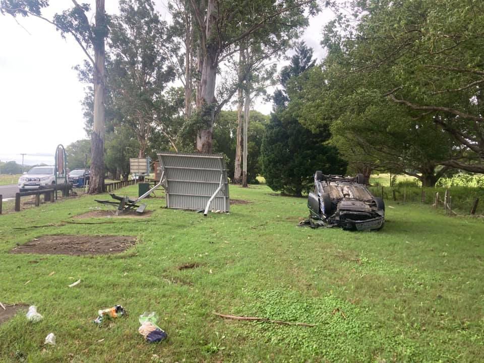 A Car Is Laying on Its Side in A Grassy Field — Alpine Towing Services in Lismore, NSW