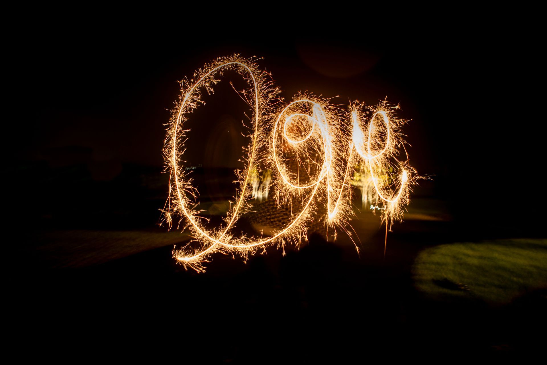 Sparkler light painting spelling “LOVE” against a dark background