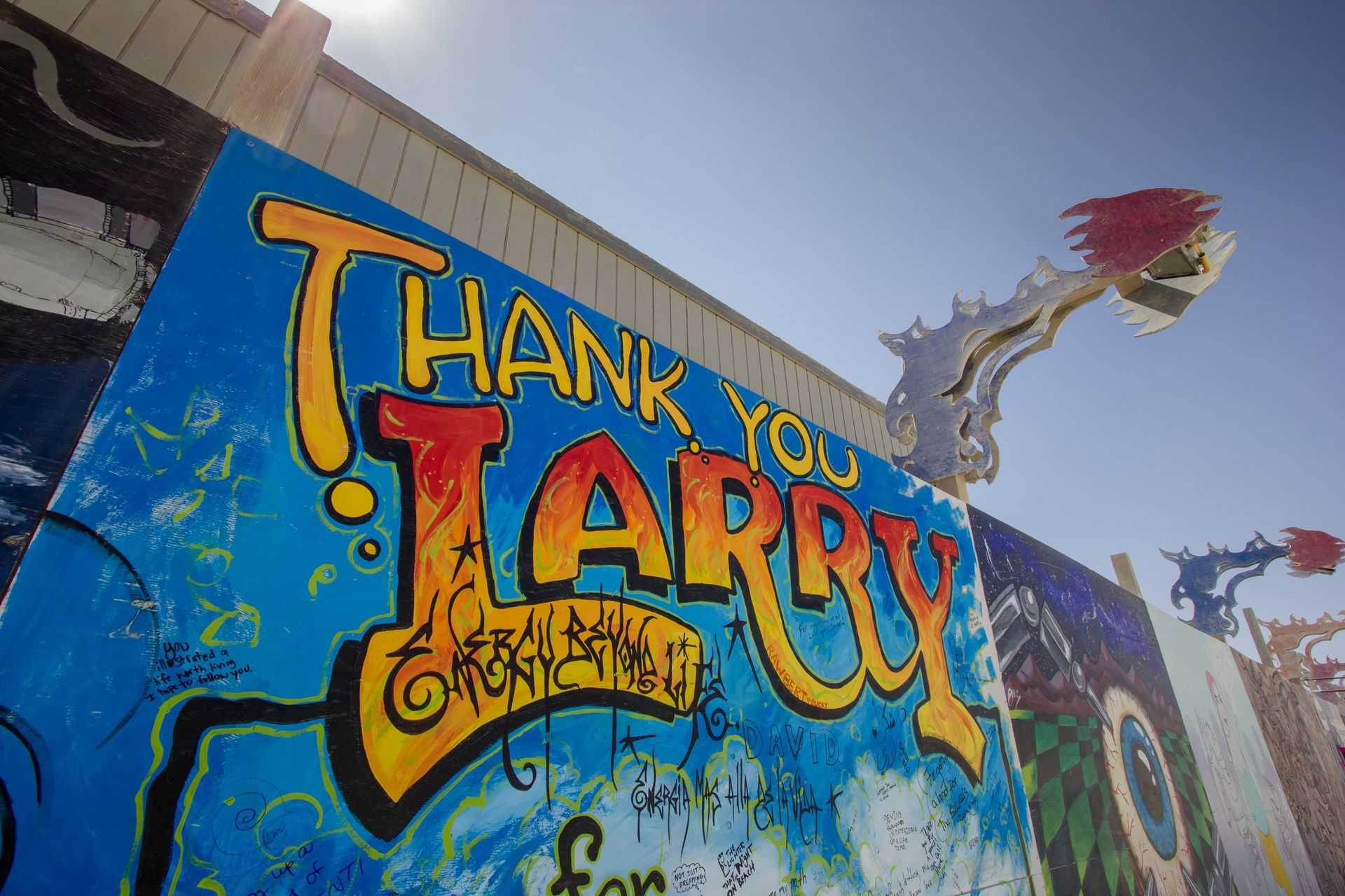 Graffiti mural reading “Thank You Barry” on a blue wall, with a dragon and roses