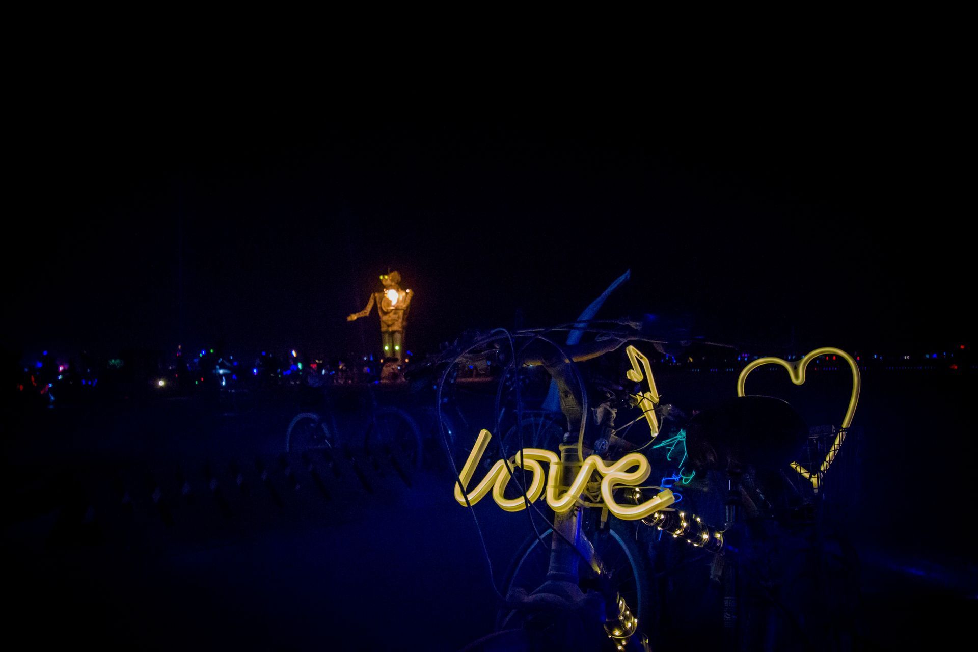 Glowing blue and gold light display with the word “love” and a heart shape at night