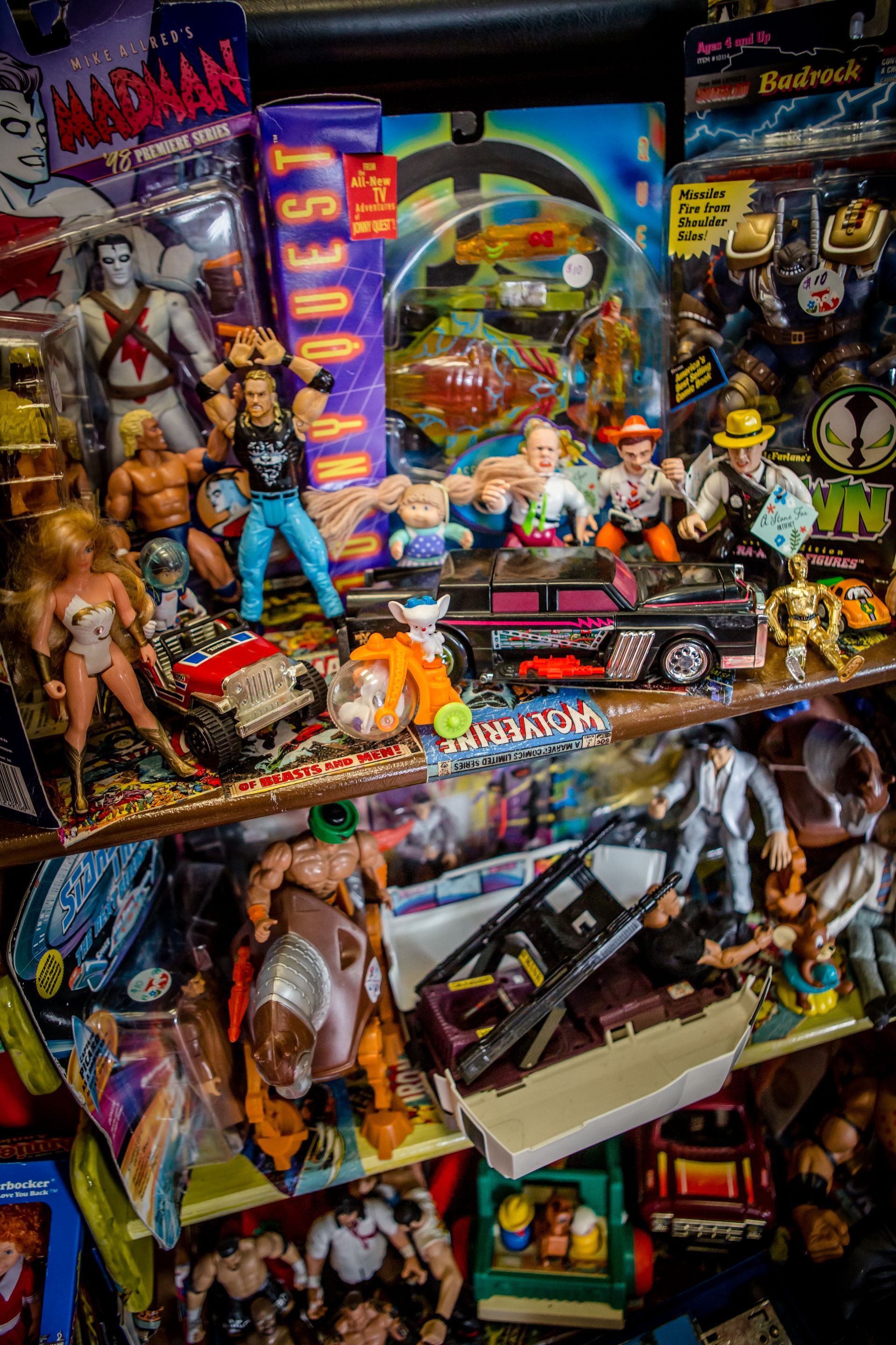 Colorful display of vintage toy action figures and boxed collectibles on crowded shelves
