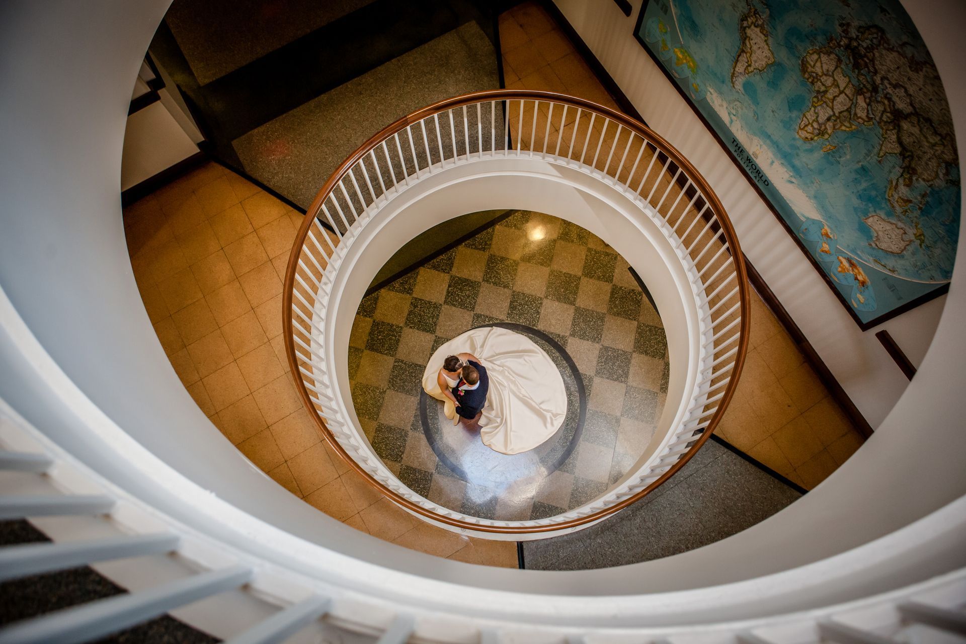 Top-down view of a spiral staircase with a person standing on the landing below