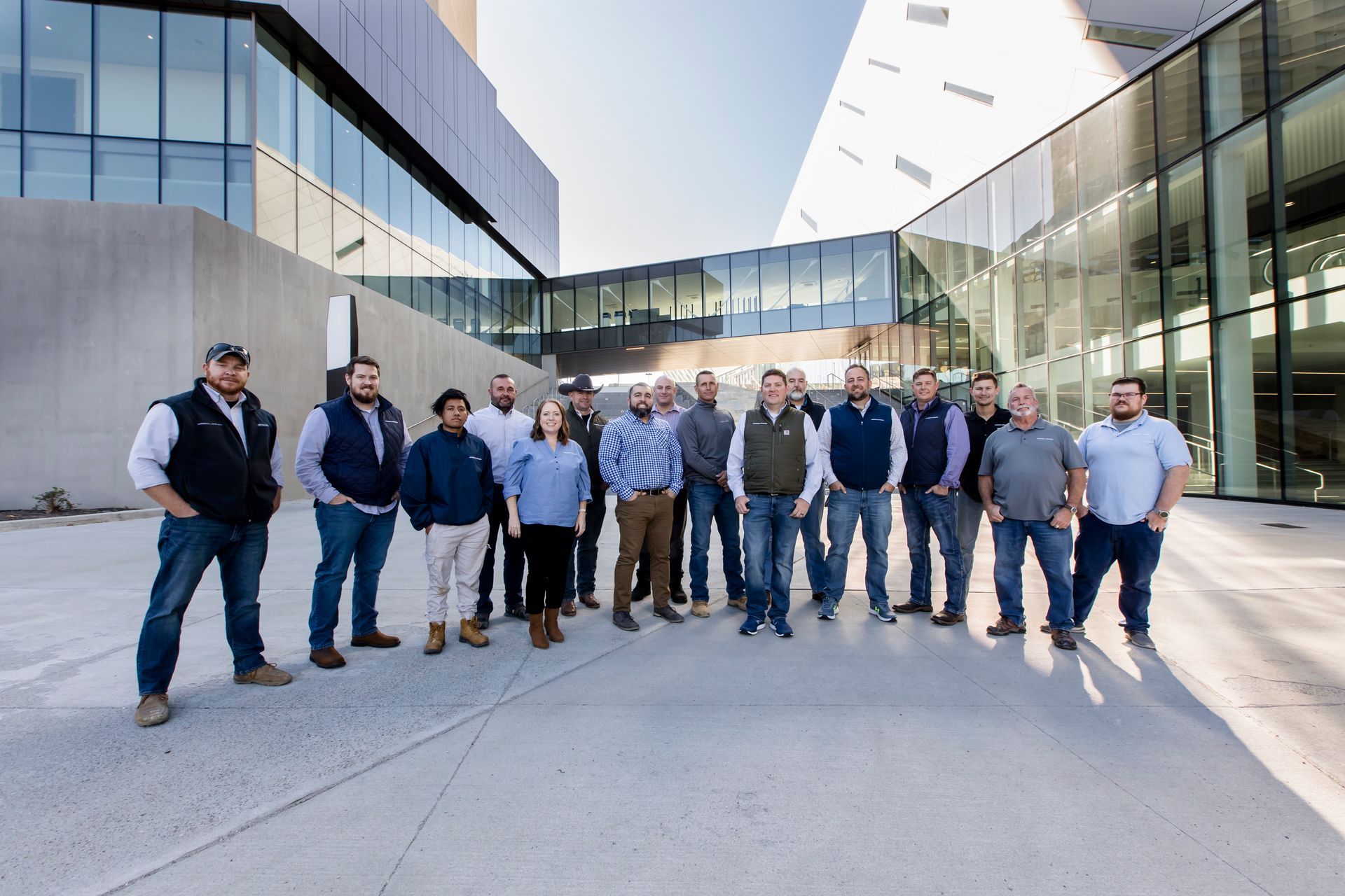 Group of people standing together outside a modern glass building in a courtyard