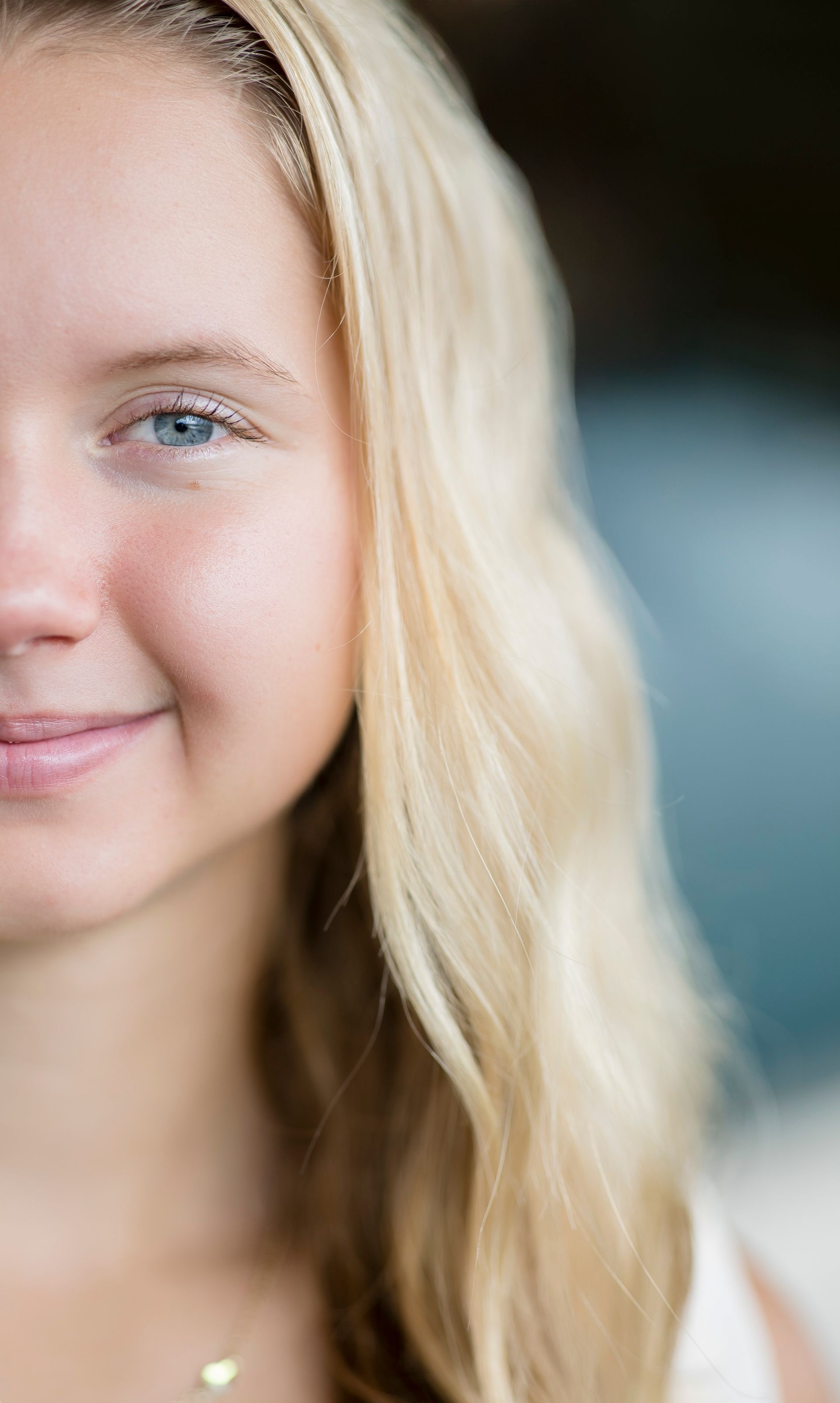 Close-up of a smiling blonde person against a softly blurred background