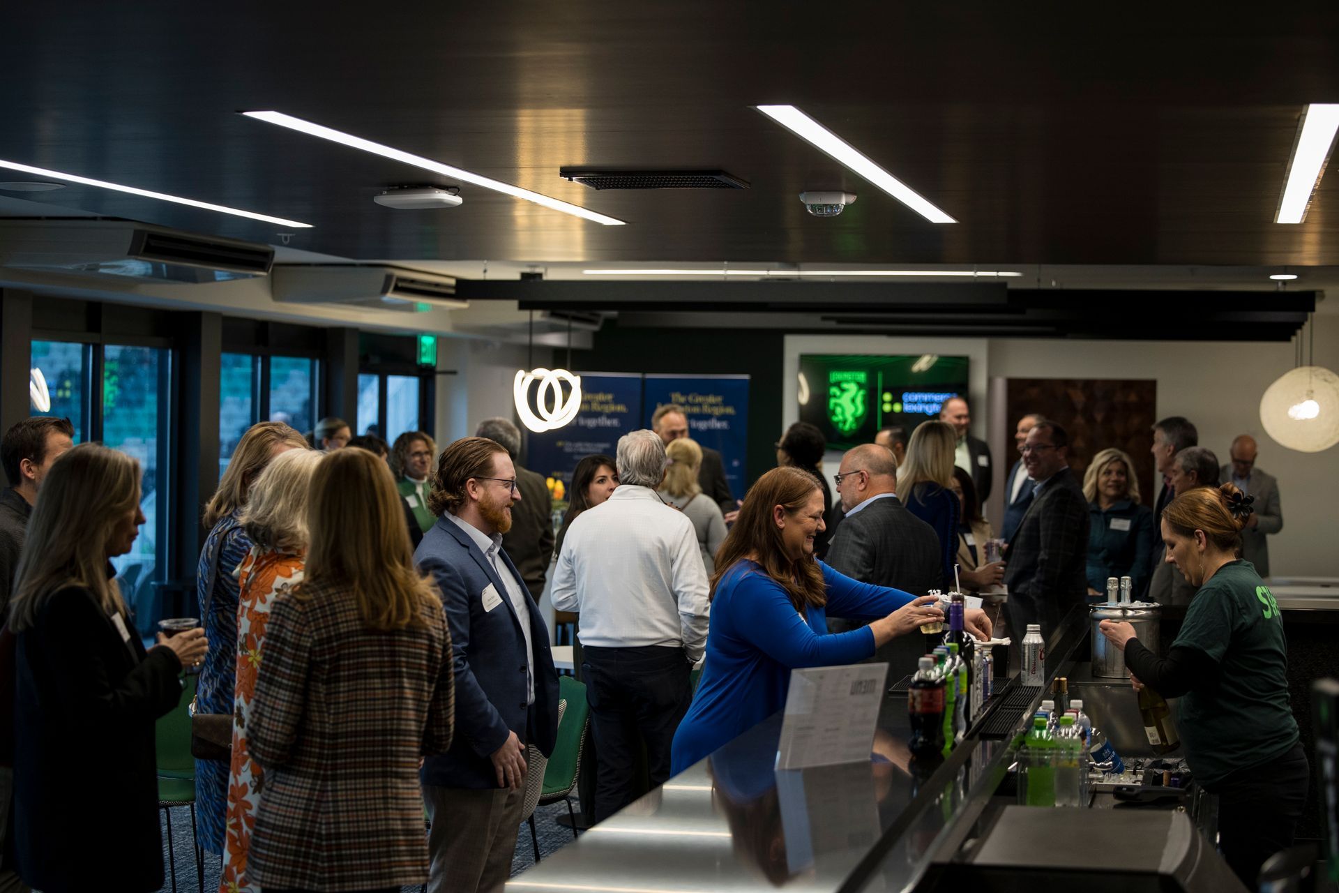 Crowded airport check-in counter with travelers and staff under overhead lights