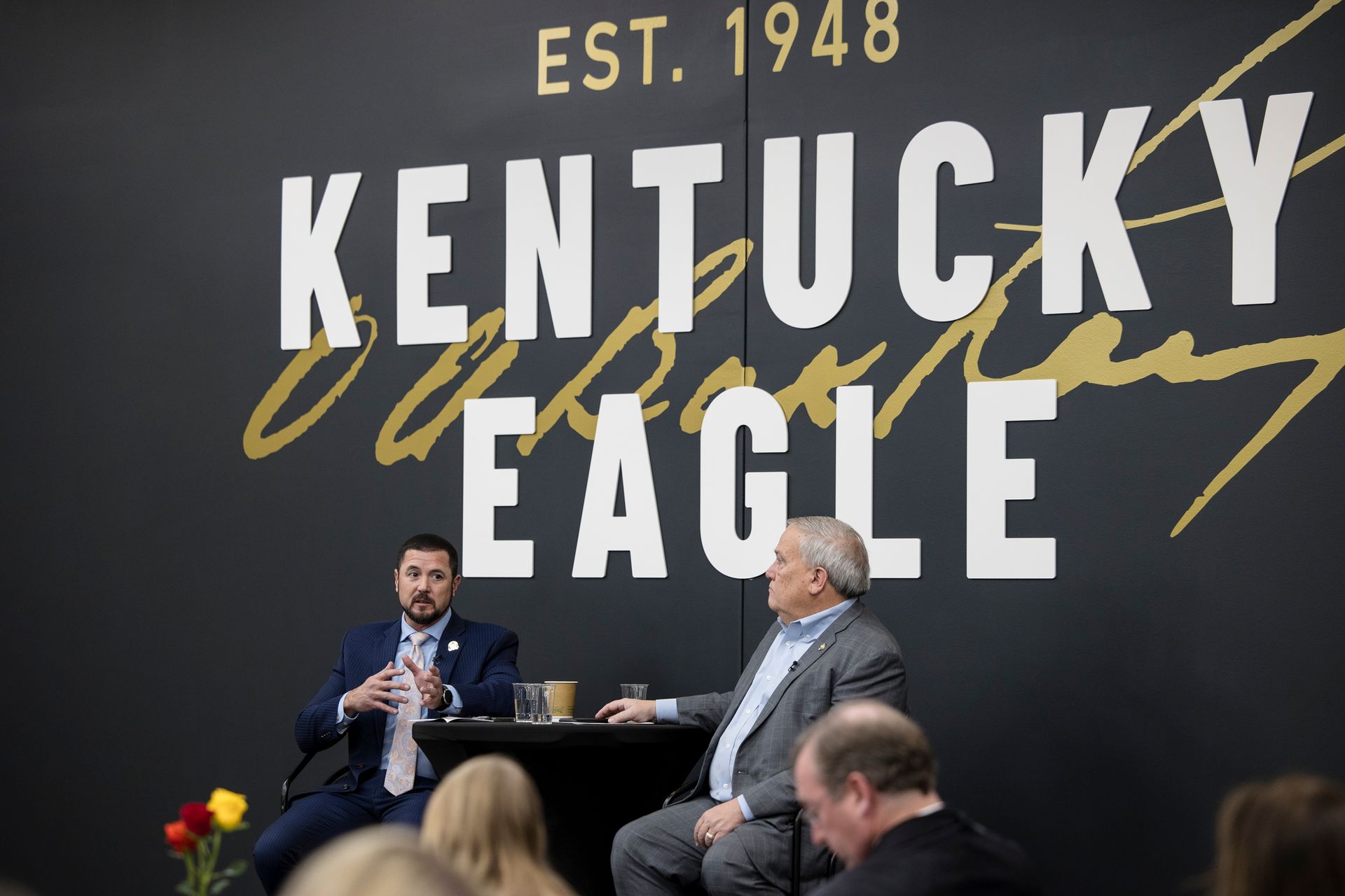 Panel discussion on a stage beneath a large “Kentucky Eagle” sign