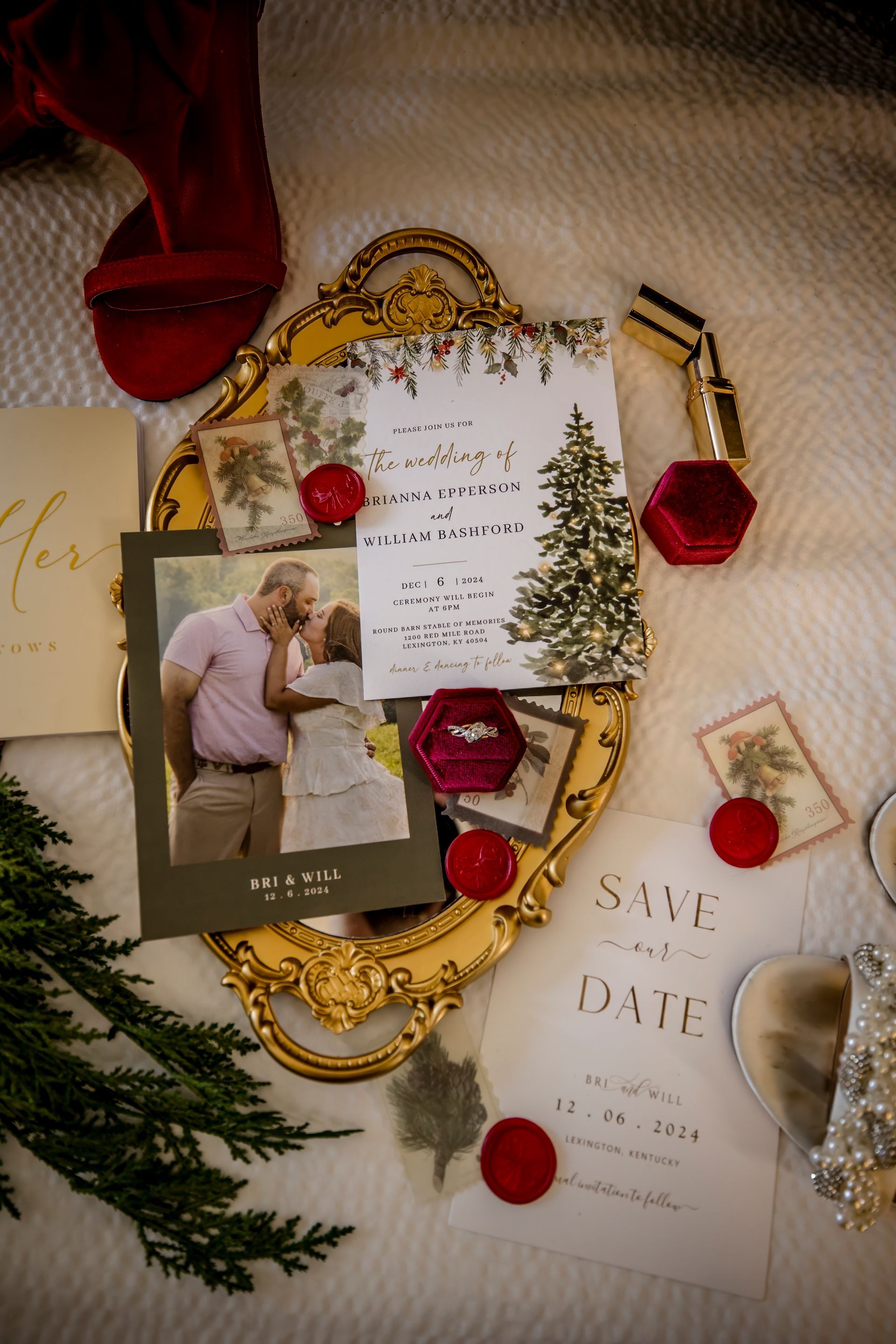 Gold-framed save-the-date cards with red wax seals, greenery, and a small couple photo on a cream backdrop