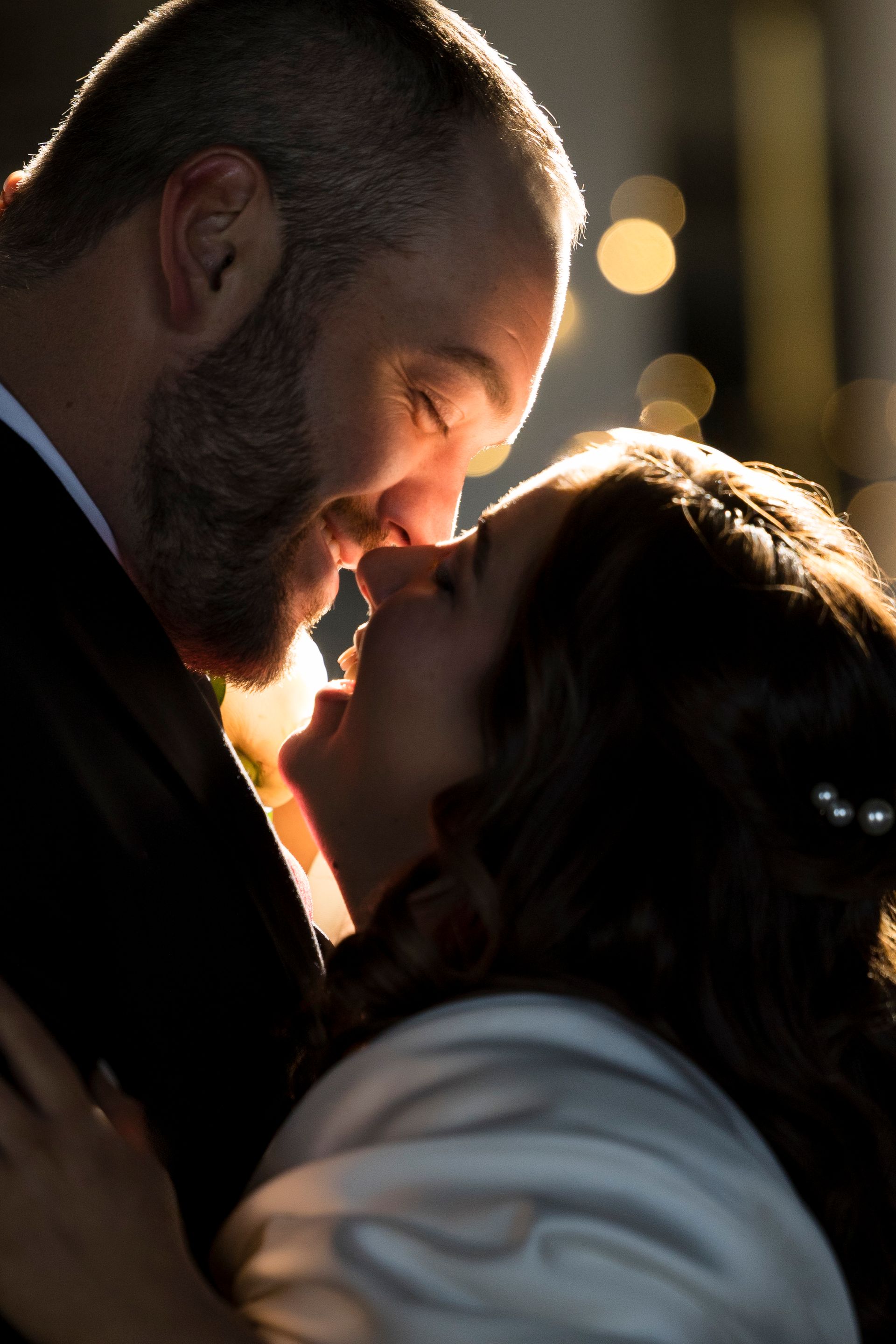 Couple kissing in close-up at night with warm, soft lighting