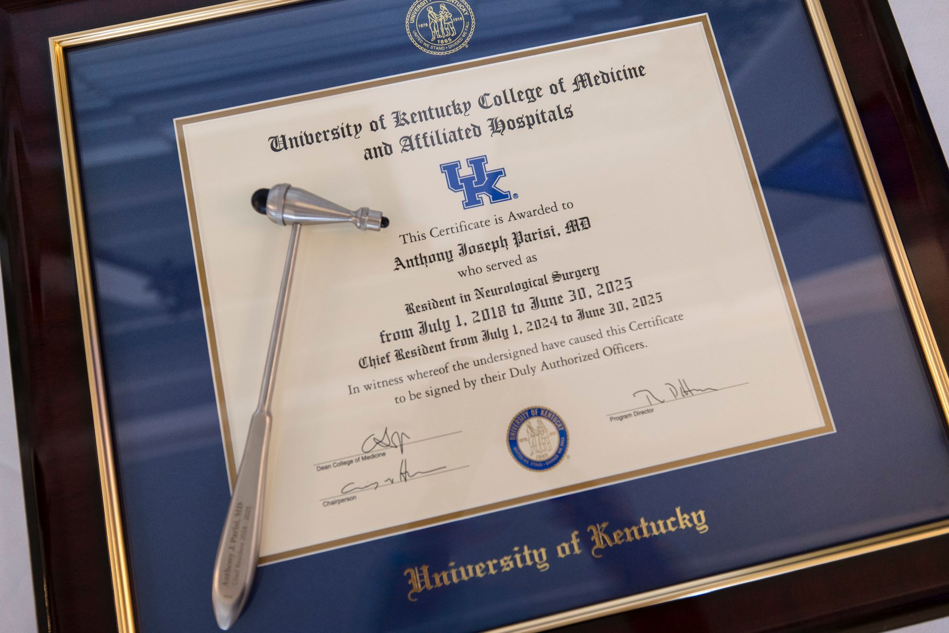 University of Kentucky diploma in blue frame with pen on top