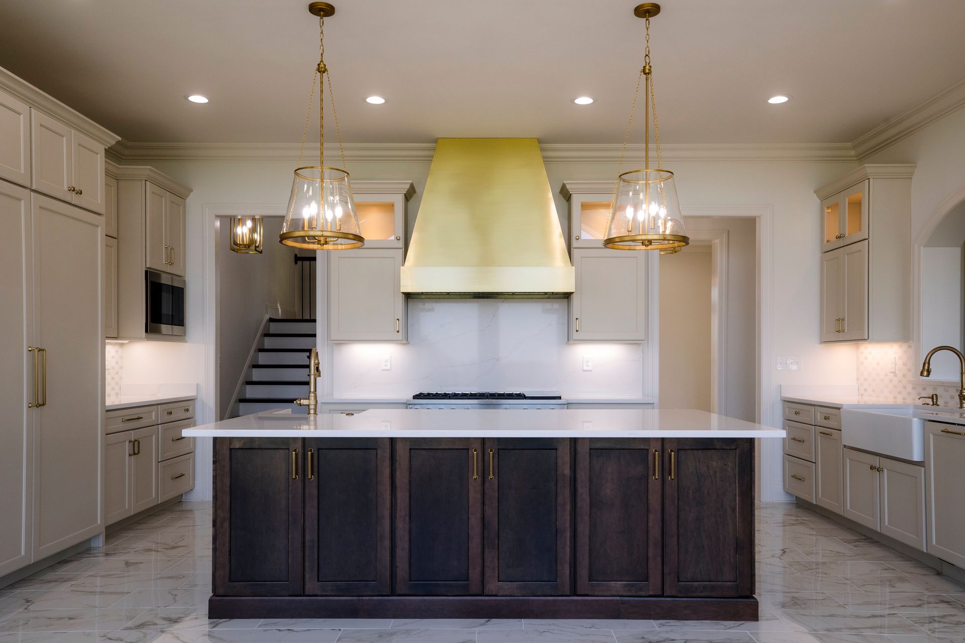 Bright modern kitchen with white cabinets, dark island, and yellow range hood