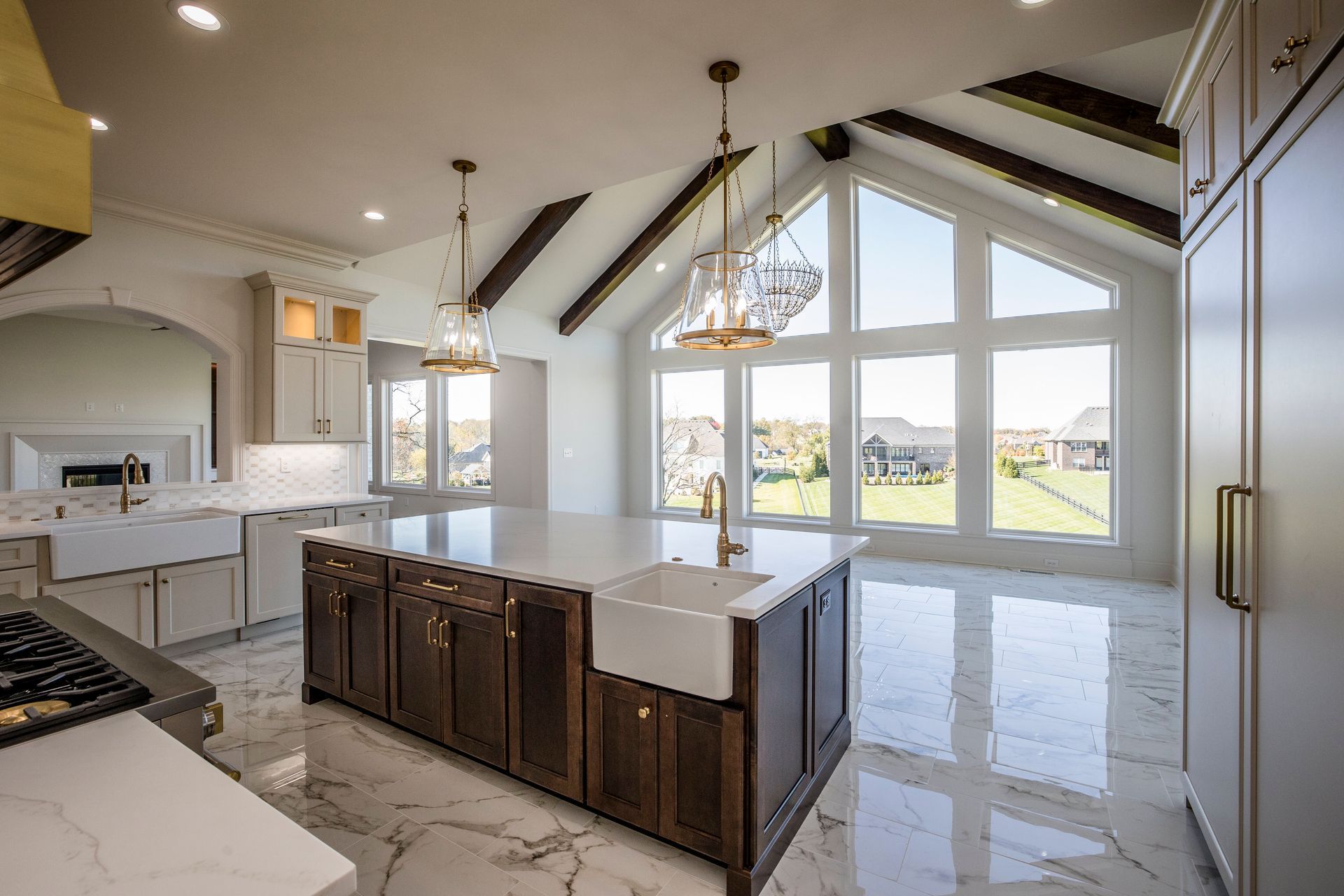 Modern kitchen and dining area with large windows, island, and vaulted ceiling in a bright open-concept home