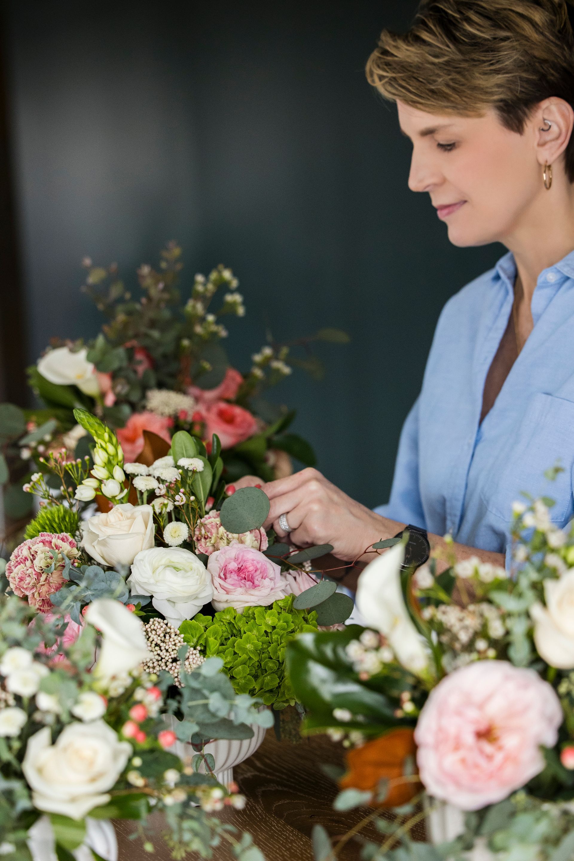 Florist arranging pink and white flower bouquets on a table