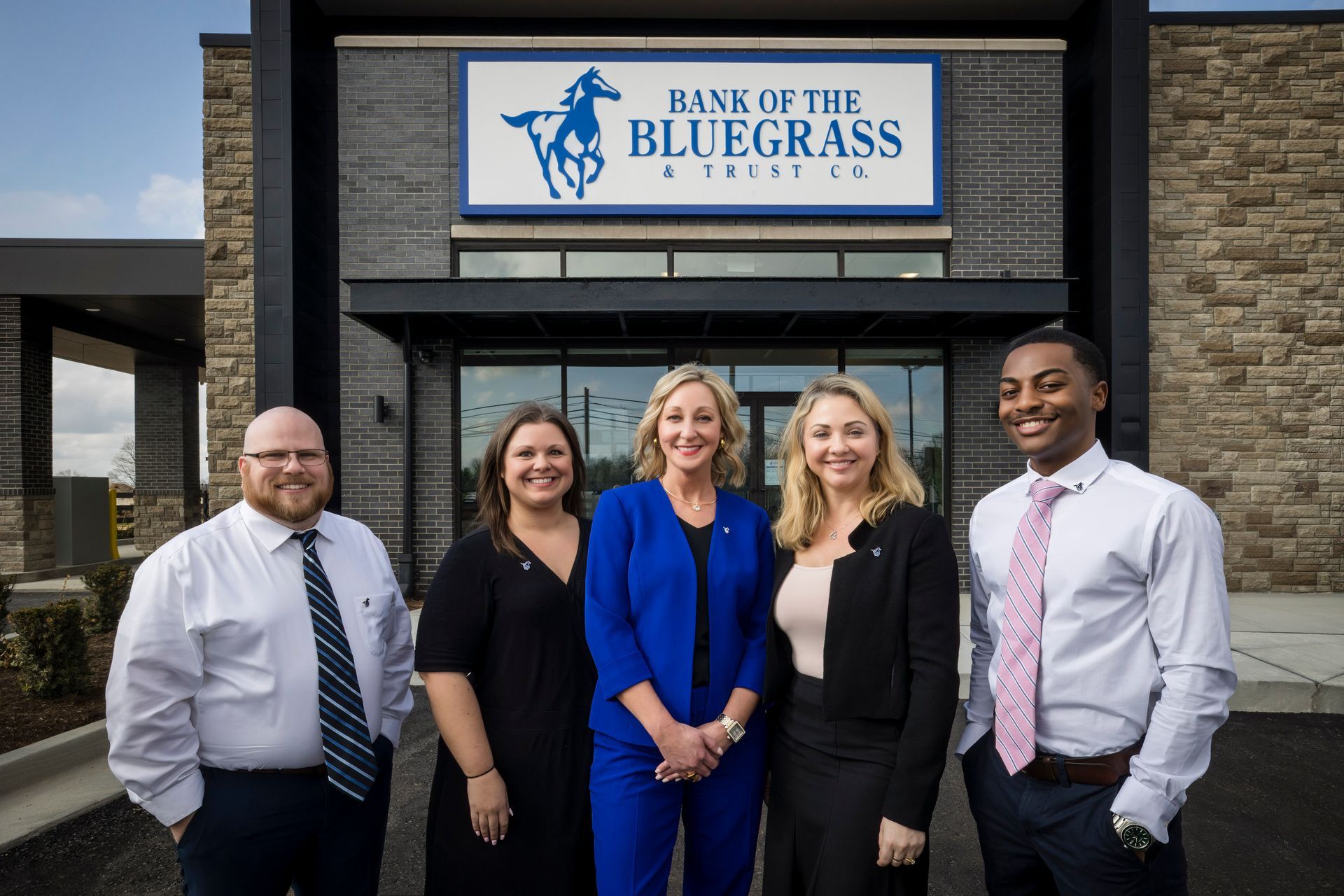 Five staff members standing outside Bank of the Bluegrass office sign