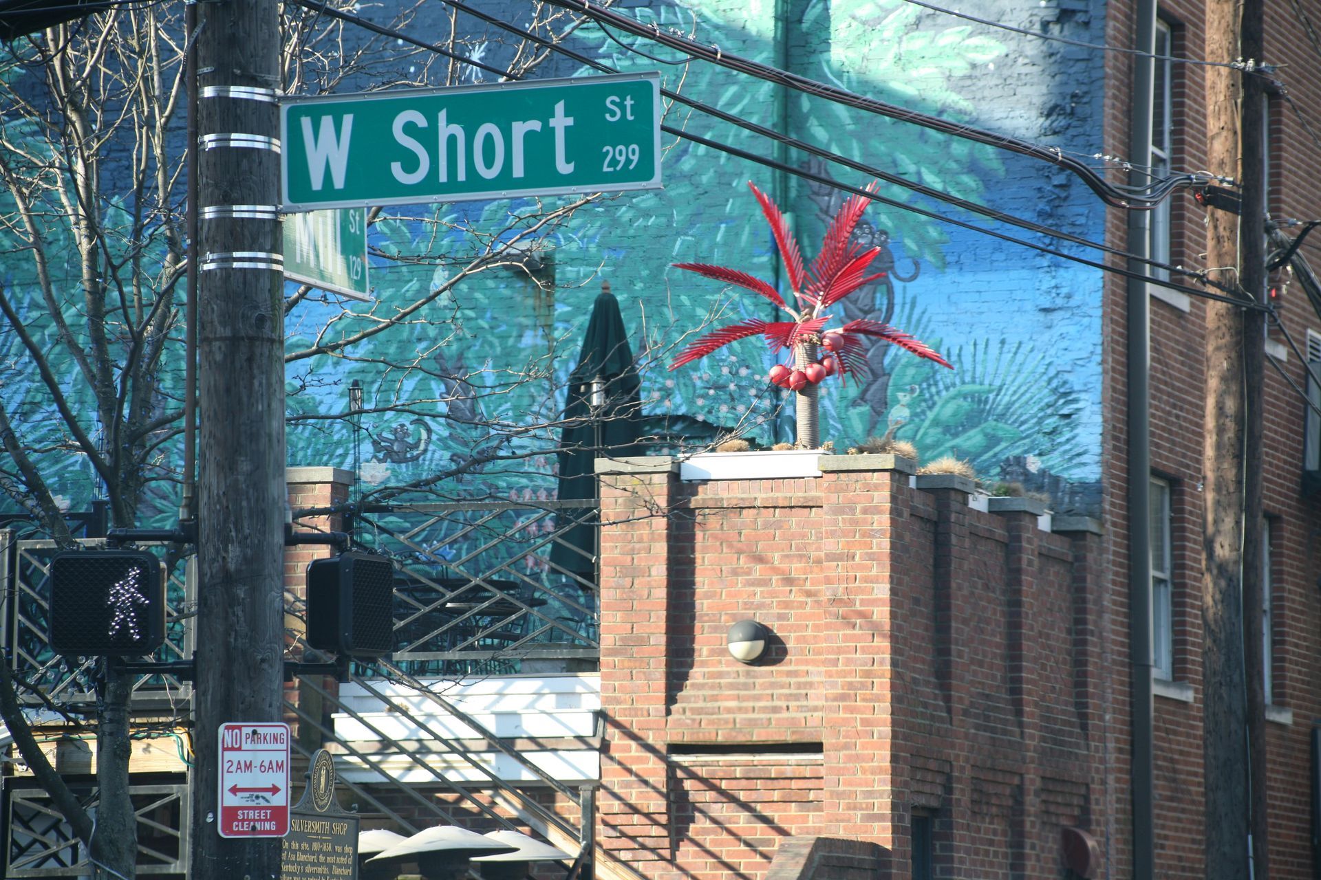 W Short St street sign above a brick building with a red sculpture and snowy urban background