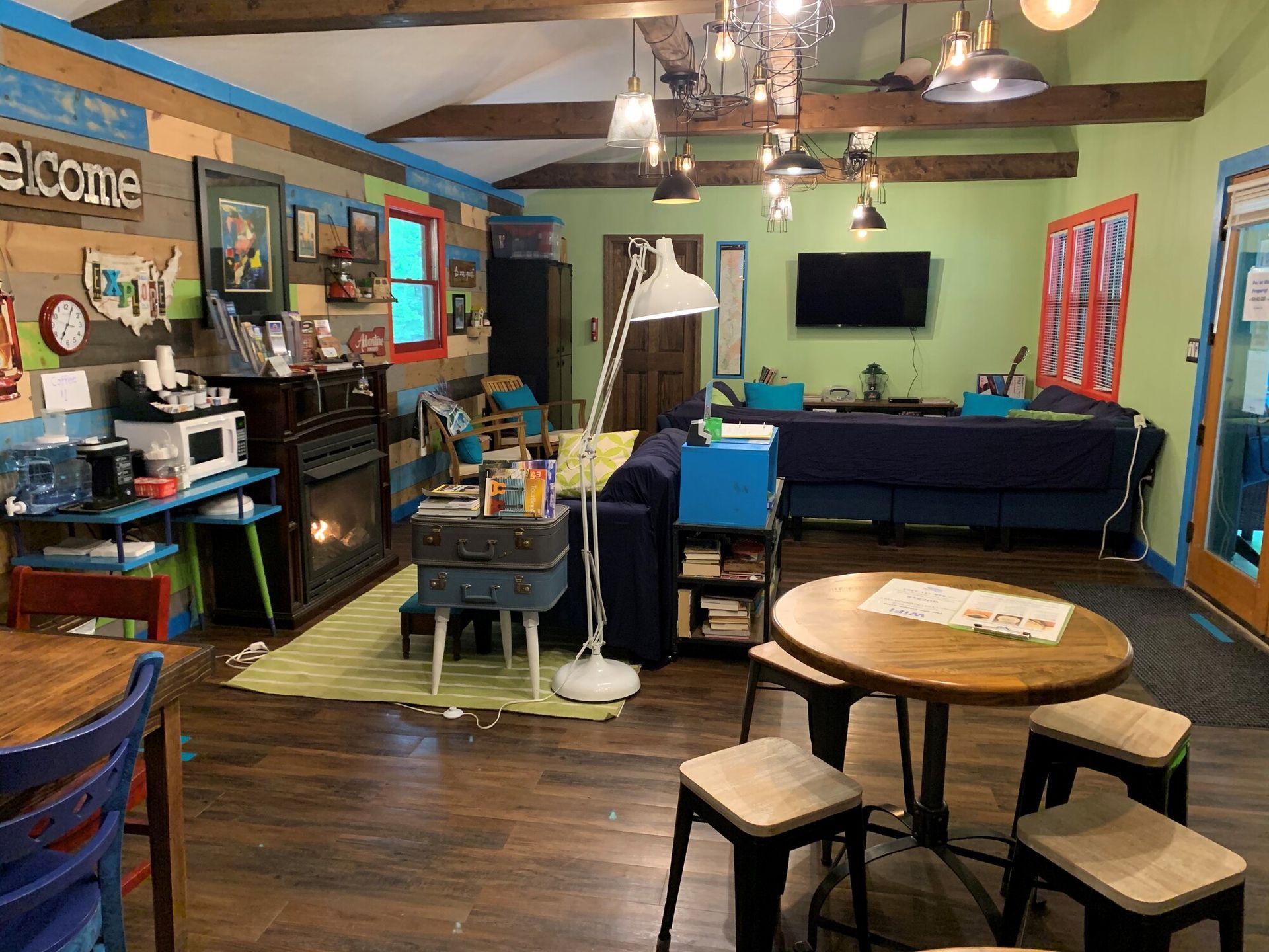 Cozy arcade-style room with games, TV, bar seating, and round table under ceiling fans