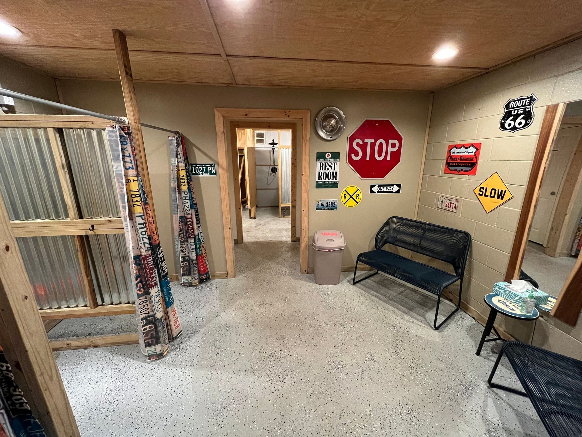 Indoor waiting area with road signs, benches, and a hallway in a small, rustic room.