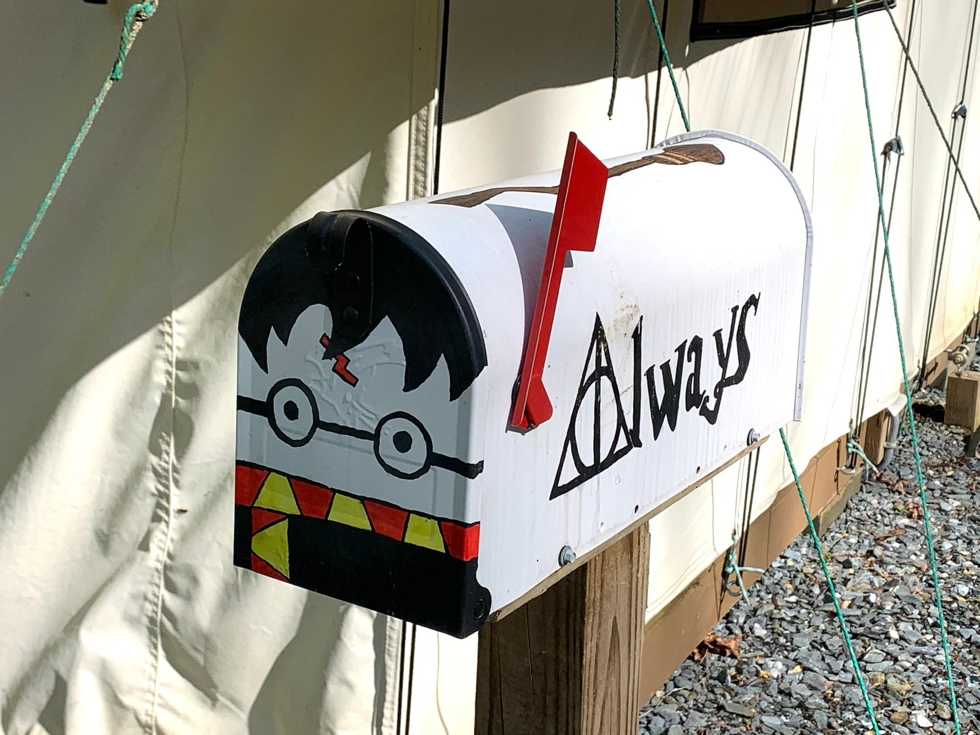 Decorated mailbox with a black-haired cartoon face and the word “Always” on the side
