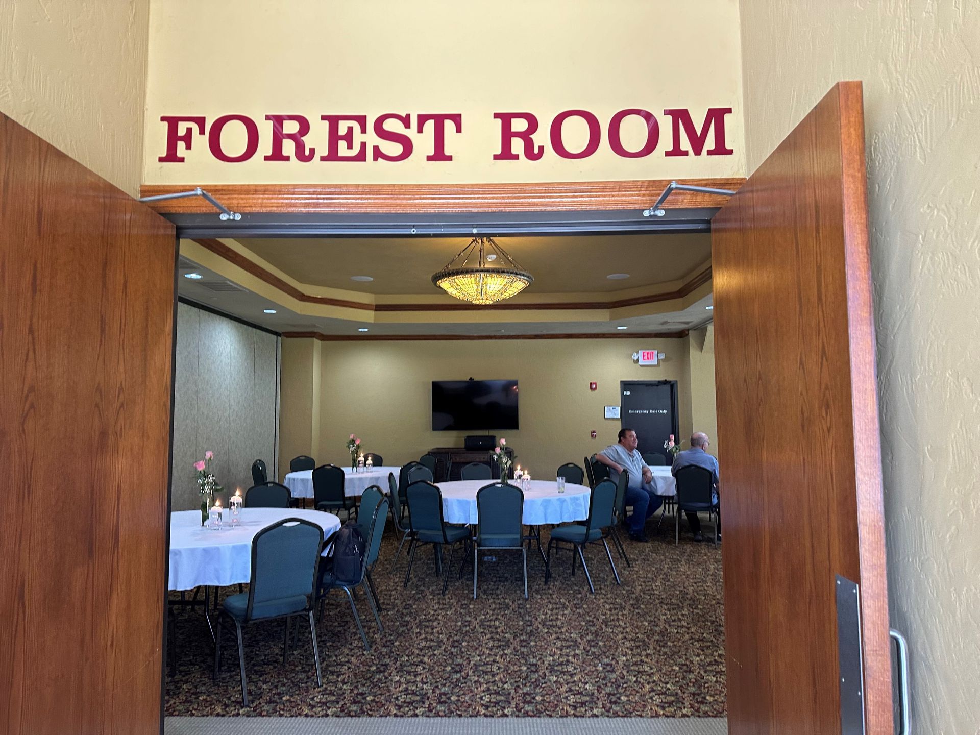 Entrance to Forest Room conference room with tables, chairs, and people seated inside
