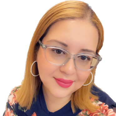 Woman with glasses and hoop earrings, smiling, wearing floral top.
