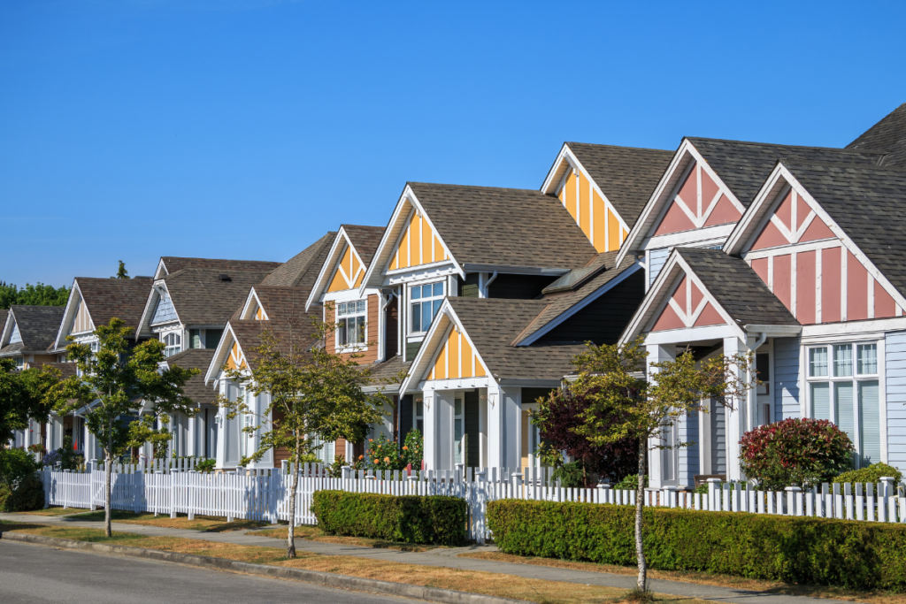 A row of colorful houses with a white picket fence