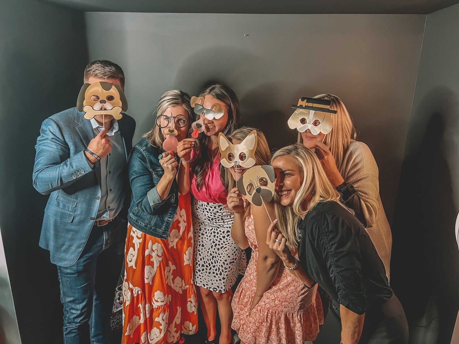 A group of people are posing for a picture with masks on their faces