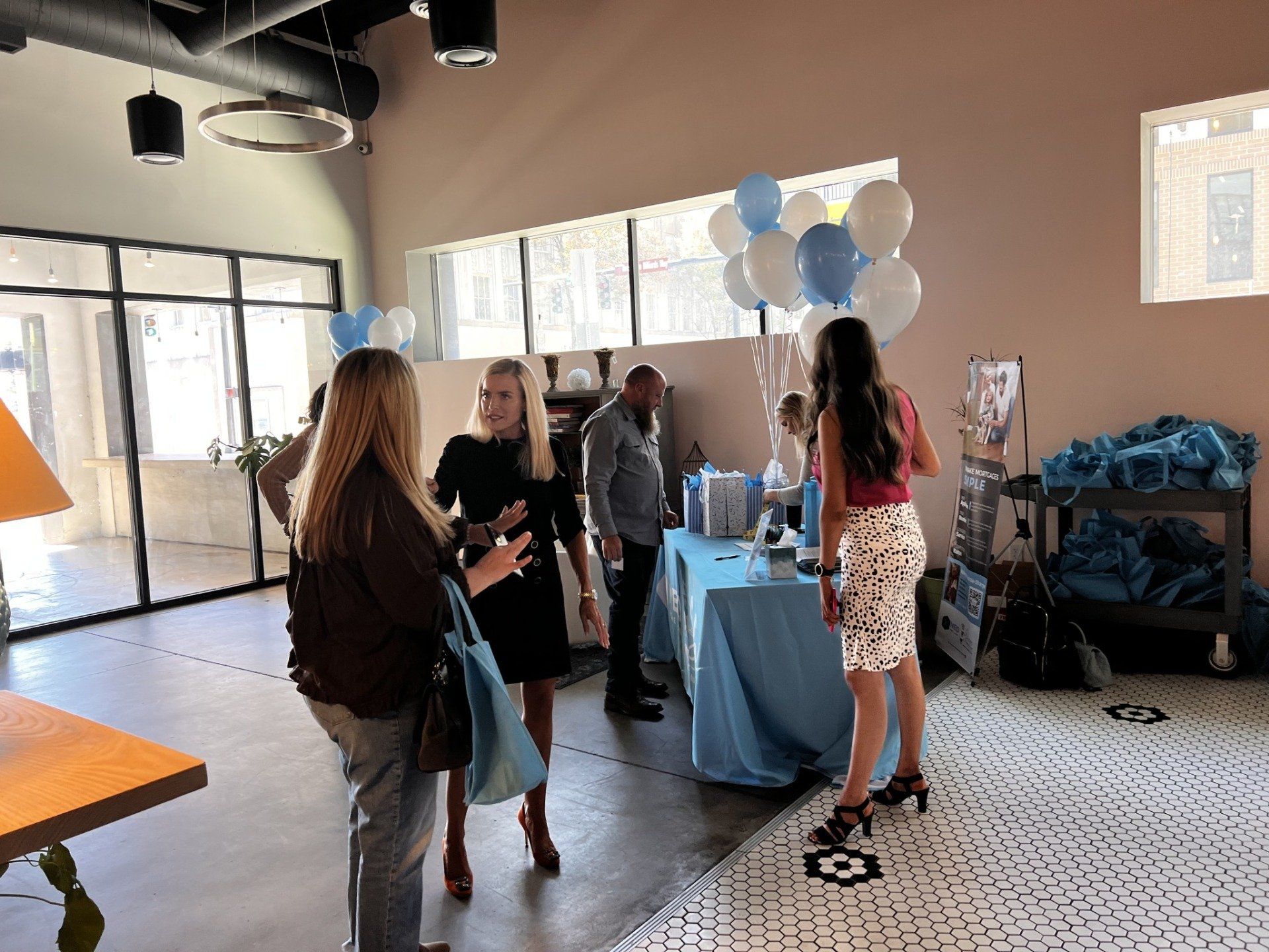 A group of people standing around a table with balloons on it