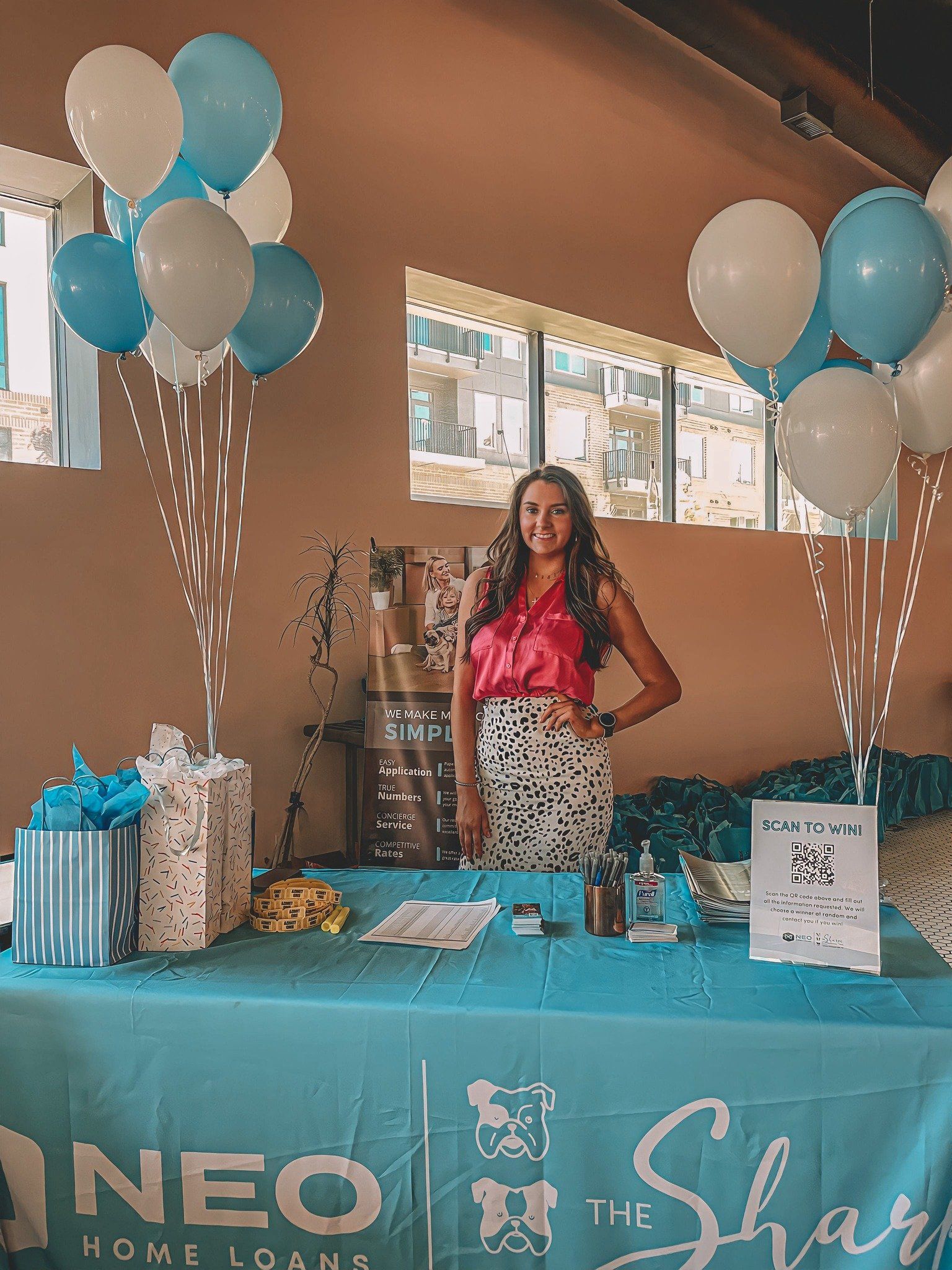 A woman stands in front of a neo home loans table