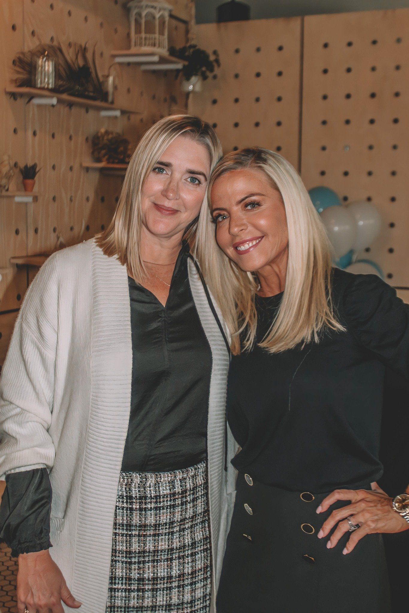 Two blonde women are posing for a picture together