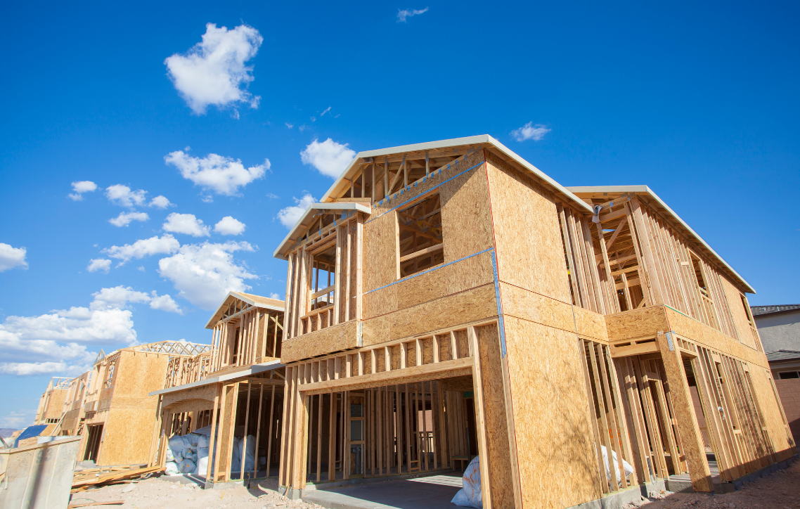 Wooden house under construction against a bright blue sky