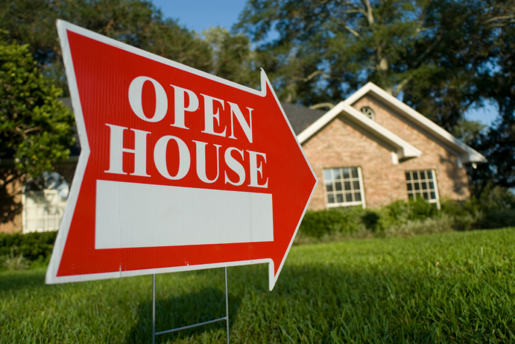 An open house sign in front of a brick house