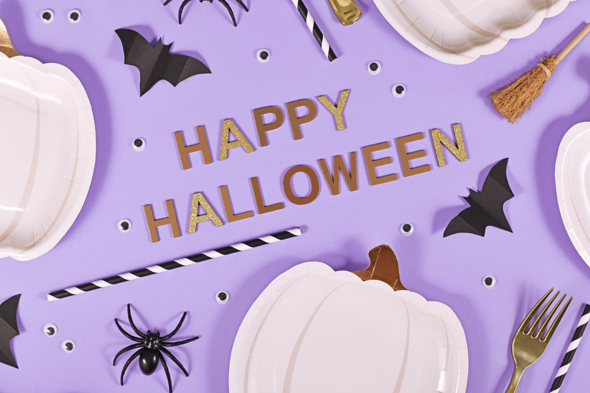A purple background with halloween decorations and the words happy halloween