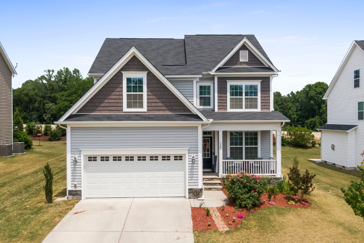 A house with a gray roof and a white garage door