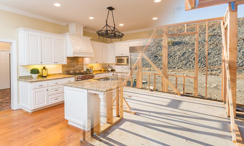 A kitchen with white cabinets and granite counter tops under construction