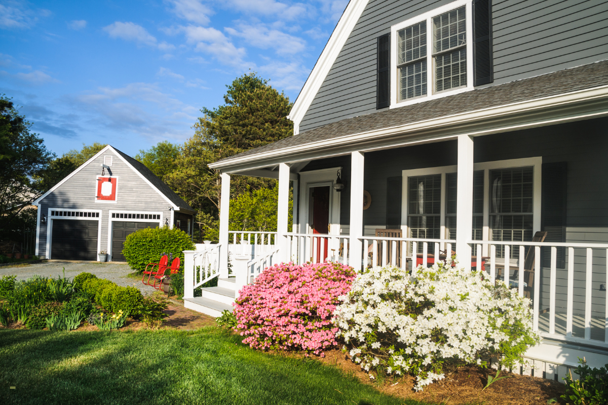 A house with a porch and flowers in front of it