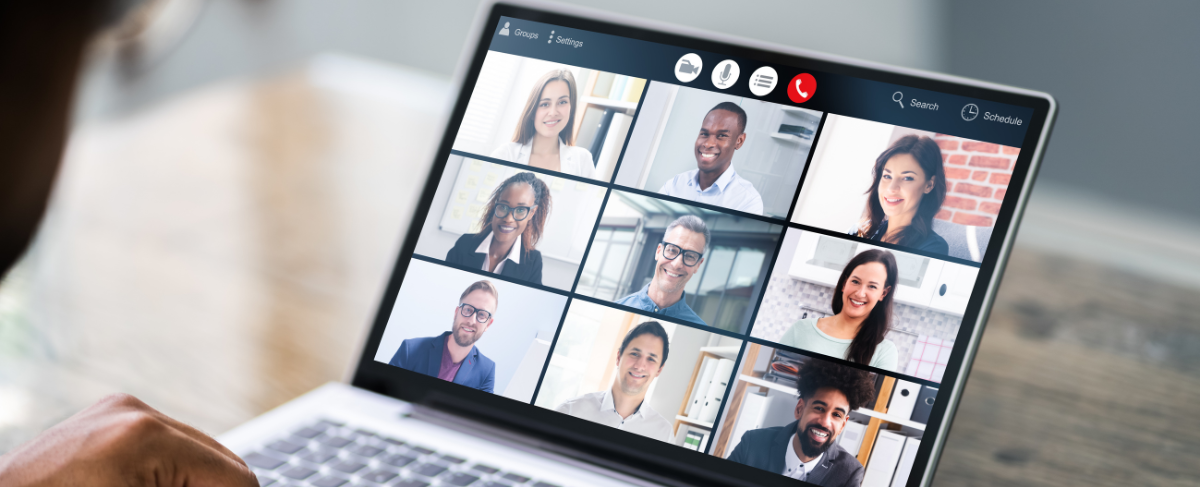 A person is using a laptop computer to have a video call with a group of people.