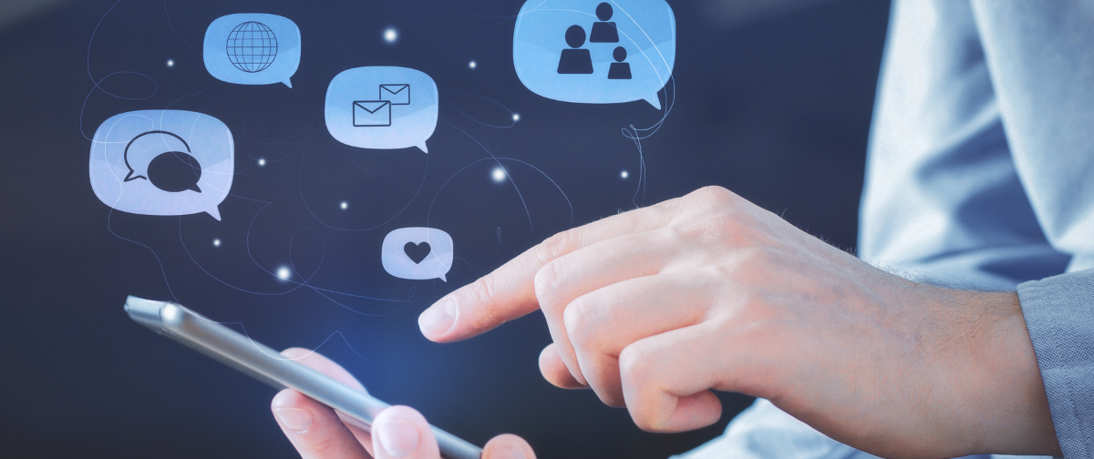 A person is using a cell phone with speech bubbles coming out of it.