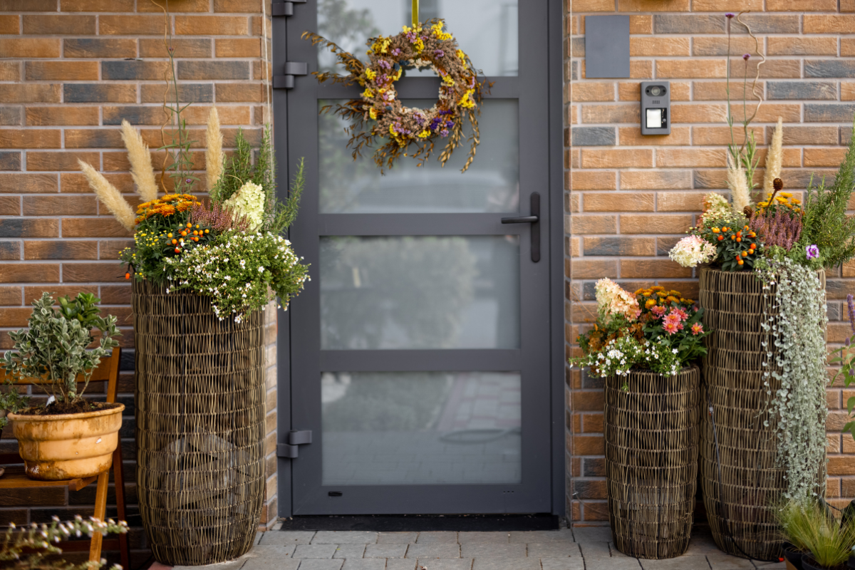 A door with a wreath on it is decorated with flowers
