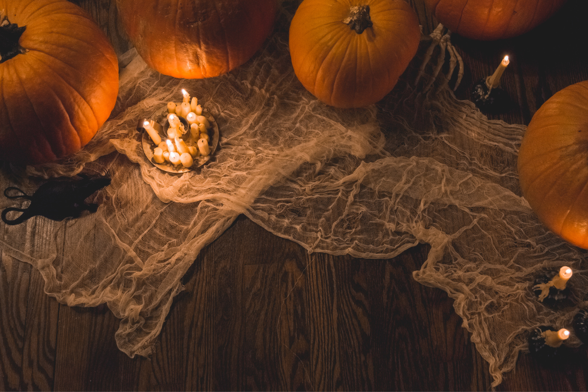 A table with pumpkins spider web and candles on it
