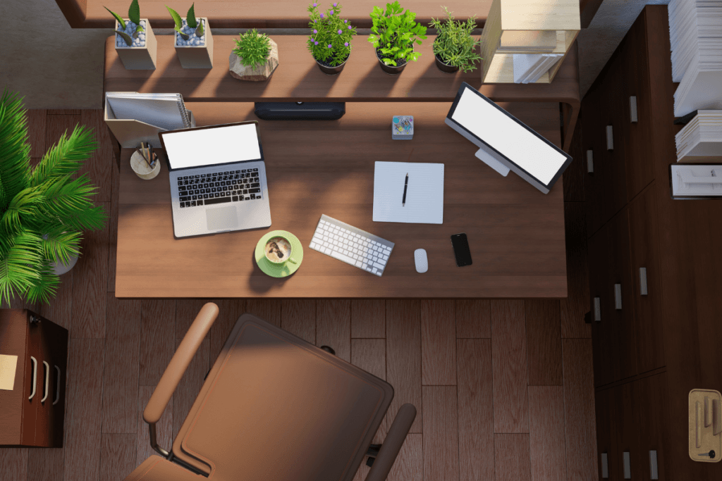 An aerial view of a desk with a laptop on it