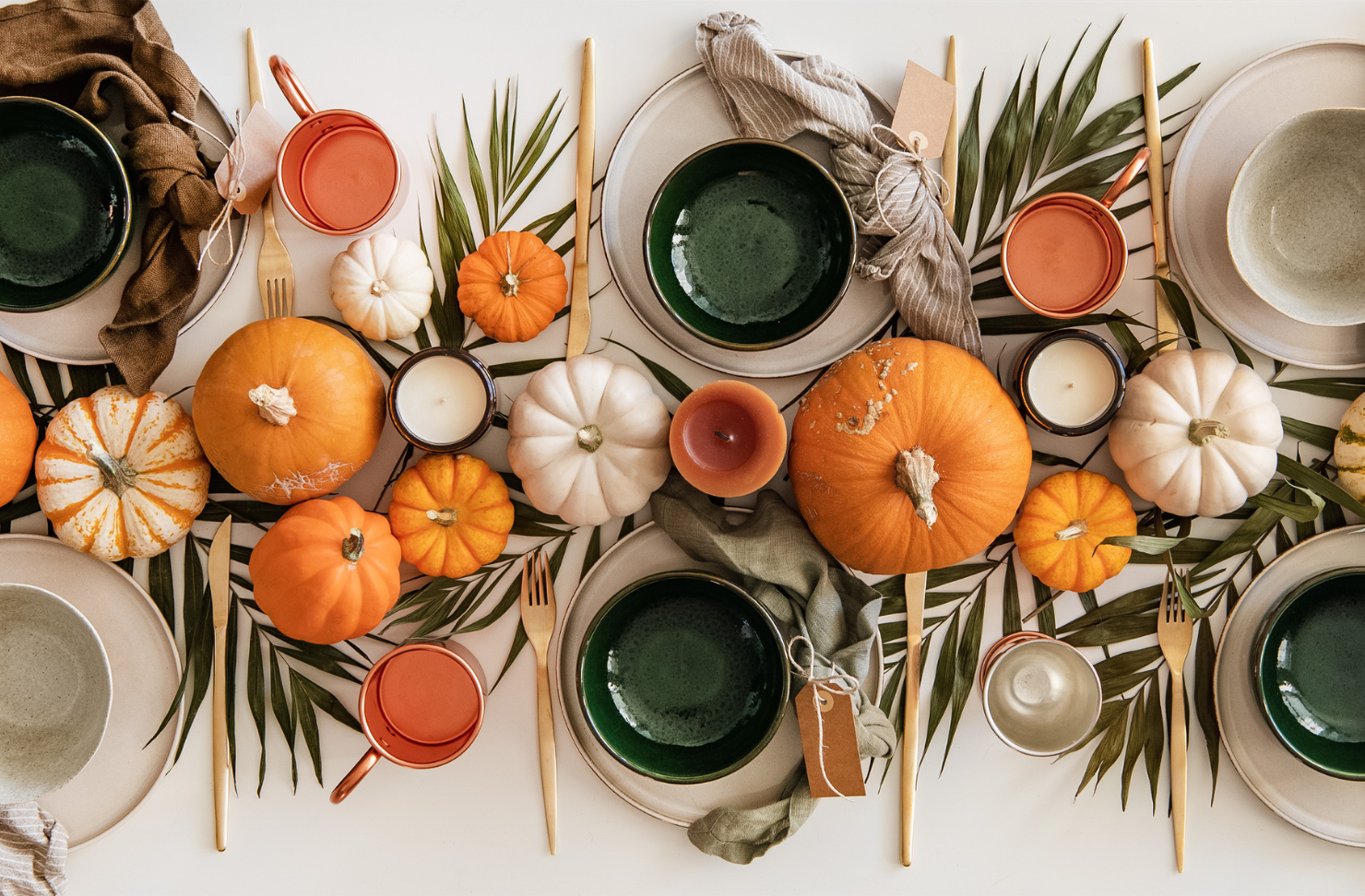 A table with plates bowls and pumpkins on it
