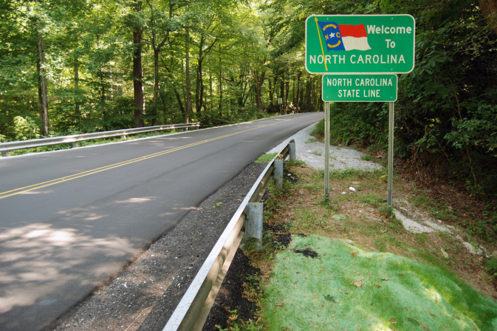 A road with a sign that says welcome to north carolina
